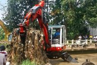 Alat berat diterjunkan untuk melakukan proses pengerukan sampah di Kali Pesanggrahan. (Sumber foto: Jurnal Depok)