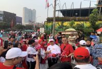 Wali Kota Depok, Supian Suri bersama Ketua TP-PKK Kota Depok, Siti Barkah Hasanah atau Cing Ikah saat membagikan bendera di kawasan HBKB Margonda, Minggu (09/08/26). (Sumber foto: Siaran Depok/AN Rafi)