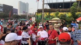 Wali Kota Depok, Supian Suri bersama Ketua TP-PKK Kota Depok, Siti Barkah Hasanah atau Cing Ikah saat membagikan bendera di kawasan HBKB Margonda, Minggu (09/08/26). (Sumber foto: Siaran Depok/AN Rafi)