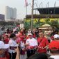 Wali Kota Depok, Supian Suri bersama Ketua TP-PKK Kota Depok, Siti Barkah Hasanah atau Cing Ikah saat membagikan bendera di kawasan HBKB Margonda, Minggu (09/08/26). (Sumber foto: Siaran Depok/AN Rafi)