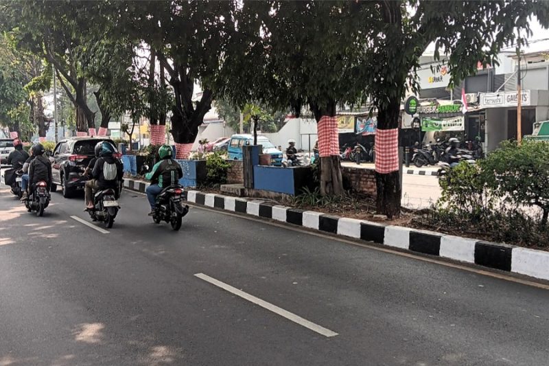 Dalam rangka memperingati HUT ke-81 RI, pepohonan di Jalan Margonda dan sejumlah lokasi lainnya di Kota Depok dibalut kain merah putih. (Sumber foto: Indoraya Today)