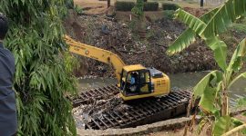 Dinas Pekerjaan Umum dan Penataan Ruang (DPUPR) Kota Depok mengerahkan unit ekskavator amfibi guna membersihkan tumpukan sampah yang menyumbat aliran Kali Baru Timur, Kecamatan Cimanggis, pada Selasa (22/09/2026). (Foto: Siaran Depok/AN Rafi)