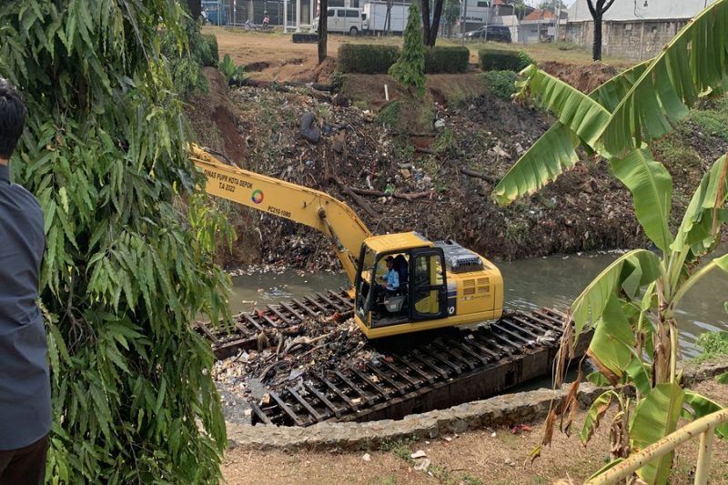 Dinas Pekerjaan Umum dan Penataan Ruang (DPUPR) Kota Depok mengerahkan unit ekskavator amfibi guna membersihkan tumpukan sampah yang menyumbat aliran Kali Baru Timur, Kecamatan Cimanggis, pada Selasa (22/09/2026). (Foto: Siaran Depok/AN Rafi)
