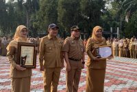 Wakil Wali Kota (Wawalkot) Depok, Chandra Rahmansyah bersama Sekretaris Daerah (Sekda), Mangnguluang Mansur menyerahkan Penghargaan Adminduk Prima 2026 kepada Kepala Disdukcapil, Mary Liziawati dan Melly Kurniawati selaku staf Disdukcapil Kota Depok pada apel pagi di Lapangan Apel Balai Kota, Senin (28/09/26). pada apel pagi Senin (28/09/2026). (Sumber foto: Siaran Depok/AN Rafi)