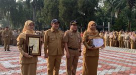 Wakil Wali Kota (Wawalkot) Depok, Chandra Rahmansyah bersama Sekretaris Daerah (Sekda), Mangnguluang Mansur menyerahkan   Penghargaan Adminduk Prima 2026 kepada Kepala Disdukcapil, Mary Liziawati dan Melly Kurniawati selaku staf Disdukcapil Kota Depok pada apel pagi di Lapangan Apel Balai Kota, Senin (28/09/26). pada apel pagi Senin (28/09/2026). (Sumber foto: Siaran Depok/AN Rafi)