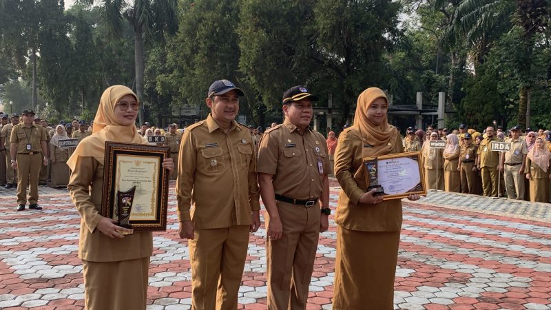 Wakil Wali Kota (Wawalkot) Depok, Chandra Rahmansyah bersama Sekretaris Daerah (Sekda), Mangnguluang Mansur menyerahkan   Penghargaan Adminduk Prima 2026 kepada Kepala Disdukcapil, Mary Liziawati dan Melly Kurniawati selaku staf Disdukcapil Kota Depok pada apel pagi di Lapangan Apel Balai Kota, Senin (28/09/26). pada apel pagi Senin (28/09/2026). (Sumber foto: Siaran Depok/AN Rafi)