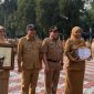 Wakil Wali Kota (Wawalkot) Depok, Chandra Rahmansyah bersama Sekretaris Daerah (Sekda), Mangnguluang Mansur menyerahkan   Penghargaan Adminduk Prima 2026 kepada Kepala Disdukcapil, Mary Liziawati dan Melly Kurniawati selaku staf Disdukcapil Kota Depok pada apel pagi di Lapangan Apel Balai Kota, Senin (28/09/26). pada apel pagi Senin (28/09/2026). (Sumber foto: Siaran Depok/AN Rafi)