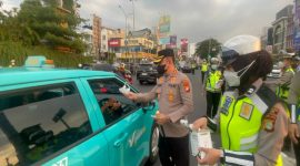 Kapolres Metro Depok, Kombes Pol. Christian Rony Putra membagikan masker di Jalan Raya Margonda pada hari Minggu, 6 September 2026. (Sumber foto: Humas Polres Metro Depok)