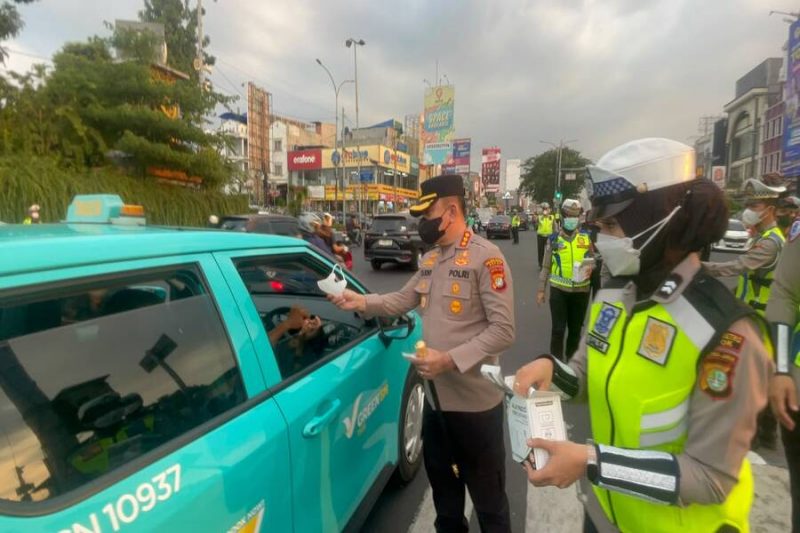 Kapolres Metro Depok, Kombes Pol. Christian Rony Putra membagikan masker di Jalan Raya Margonda pada hari Minggu, 6 September 2026. (Sumber foto: Humas Polres Metro Depok)