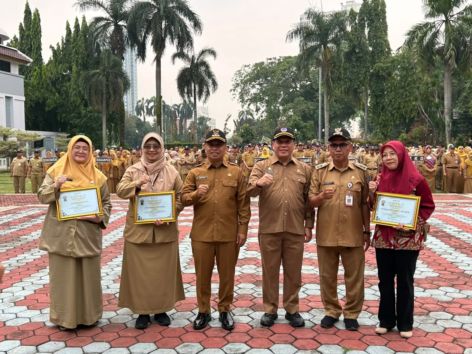 Penyerahan Piagam Penghargaan dari Pemprov Jabar atas capaian peningkatkan cakupan imunisasi tahun 2026 dilakukan langsung oleh Wali Kota Depok, Supian Suri, dengan didampingi Sekda Depok. Penghargaan tersebut diberikan kepada Dinkes Depok, Puskesmas Pasir Putih, serta Posyandu Bunga Rampai 1 di Lapangan Apel Balai Kota Depok pada Senin (12/10/26). (Foto: Diskominfo Depok)