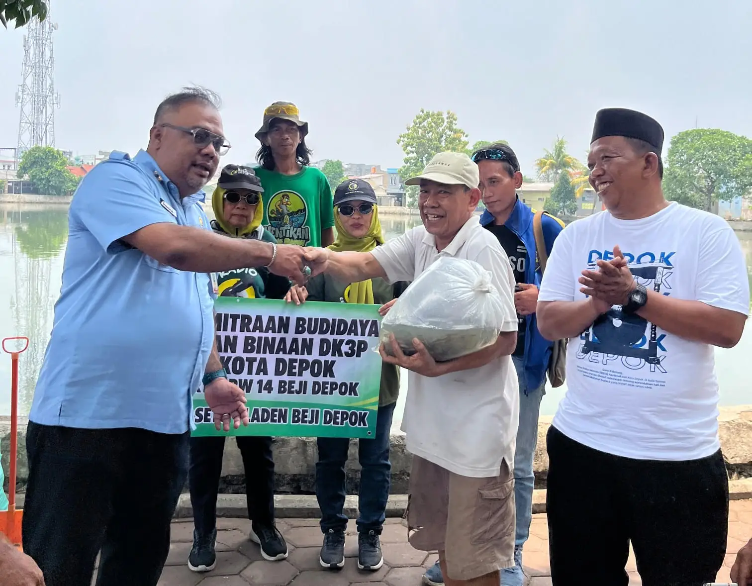 Kegiatan pembersihan Situ Pladen diwarnai dengan penyerahan 1.500 bibit ikan nila dan lele kepada Pokmas Situ Pladen pada Selasa (13/10/2026). (Foto: Dok. Lurah Beji).